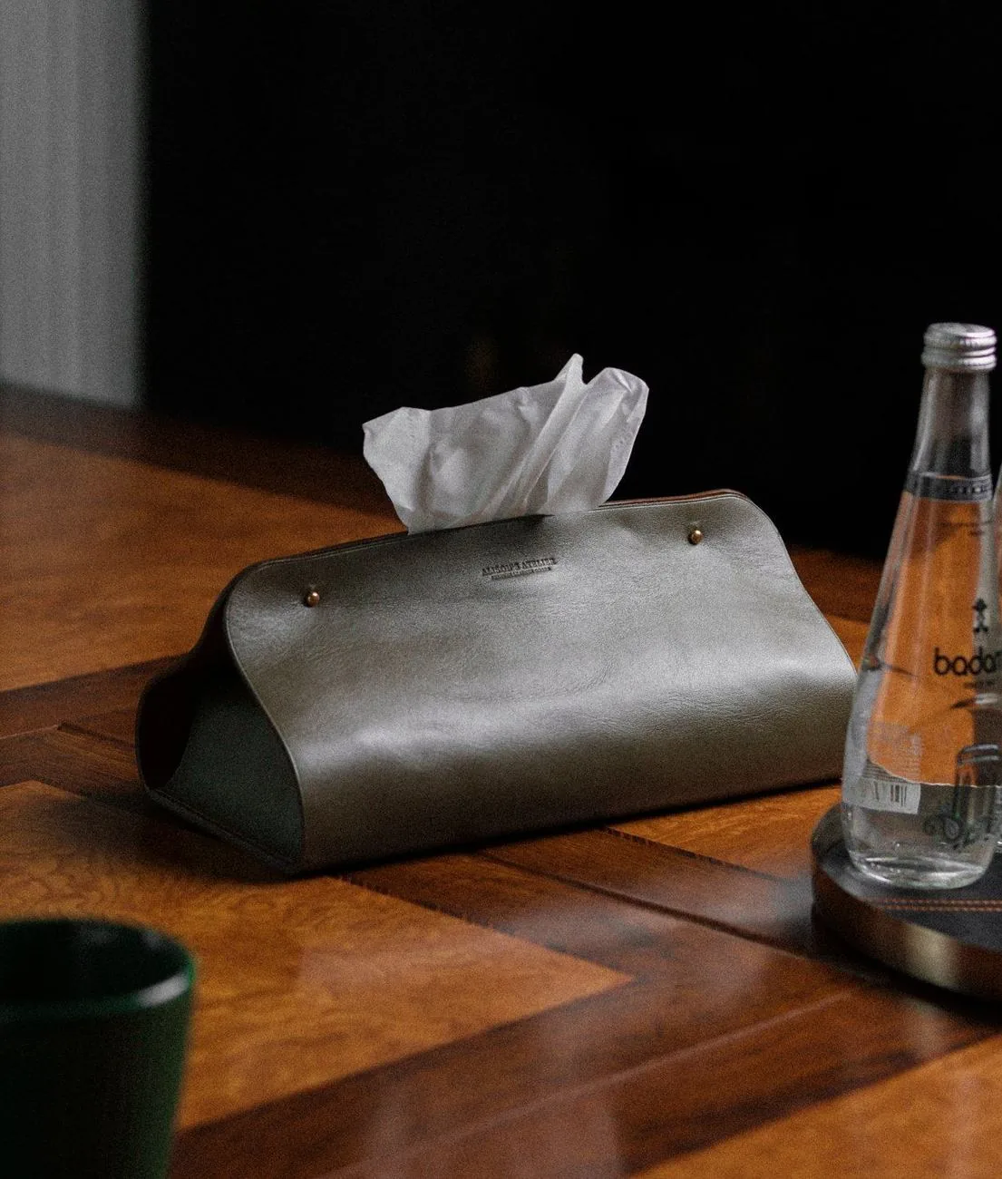 Masa üzərində Alison's Atelier loqolu dəri salfet qabı